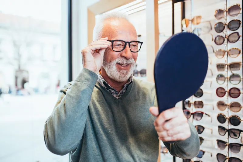 Un homme essaie une nouvelle monture devant le miroir