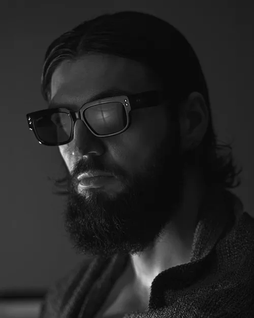Un homme porte des lunettes de soleil à monture noire